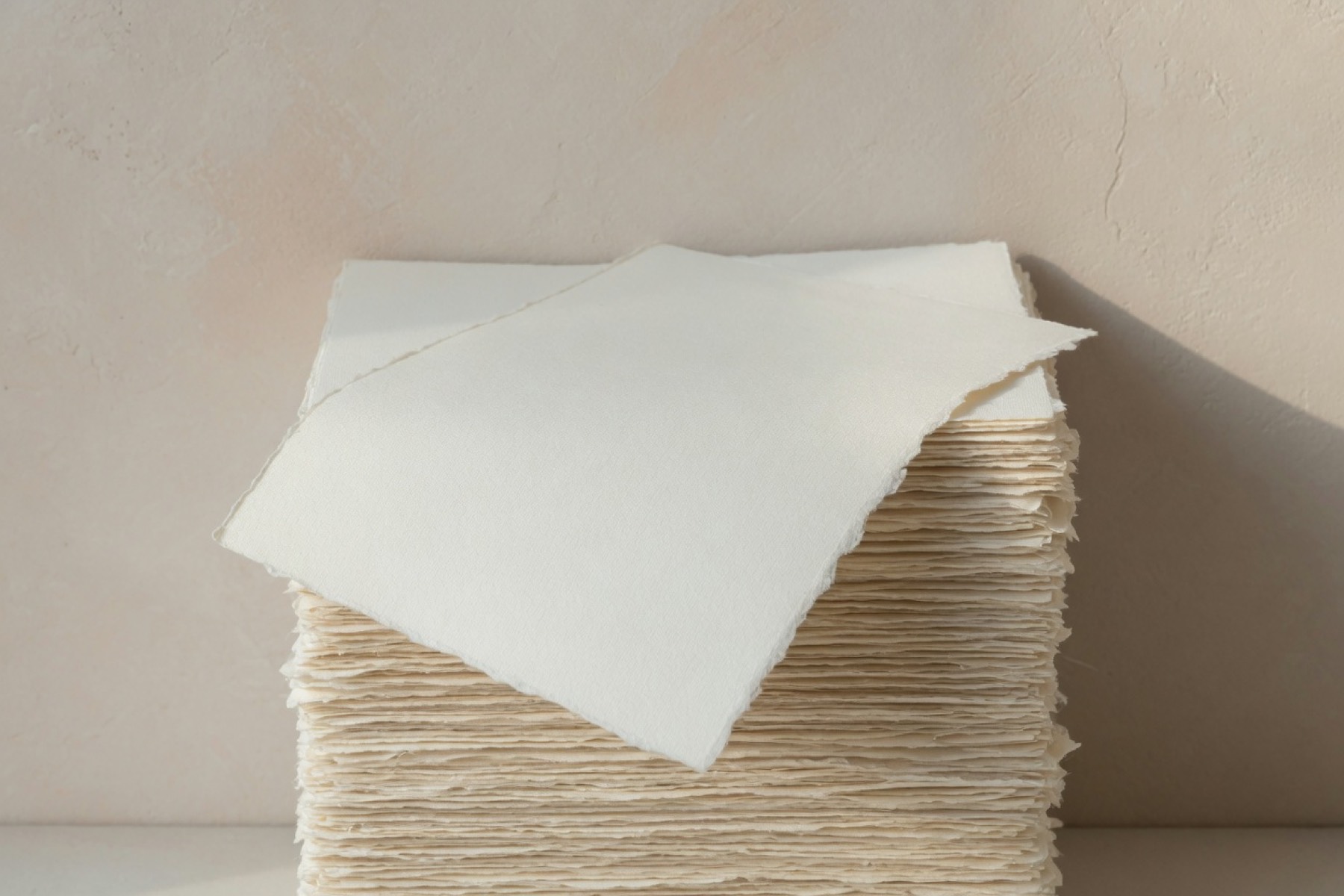 A tall stack of thick cream cotton paper.